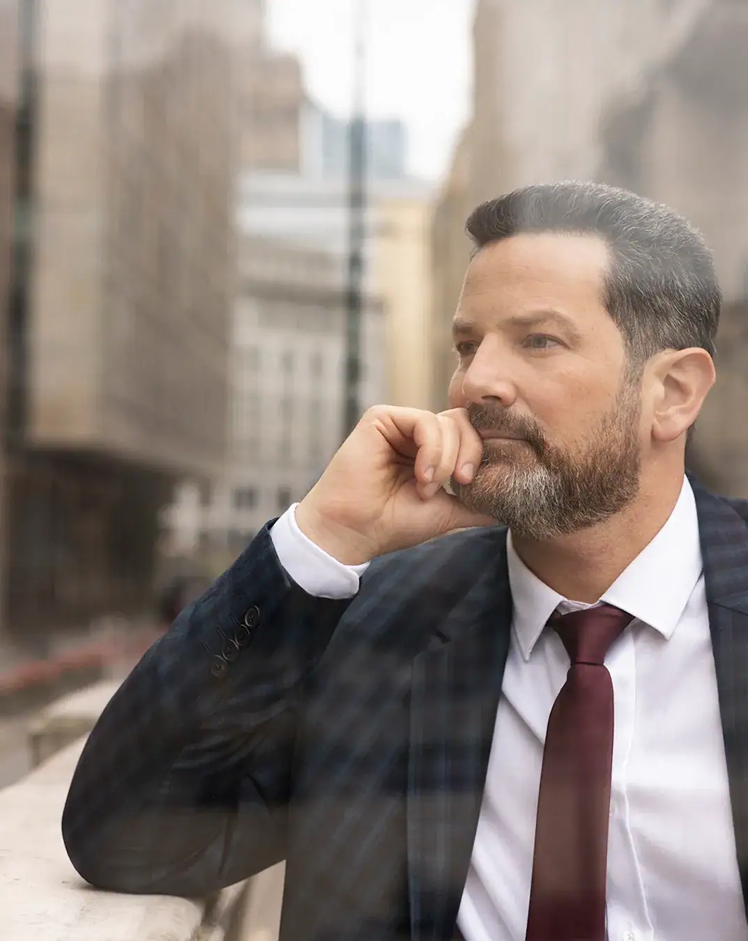 Reflective businessman contemplating success in an urban environment.